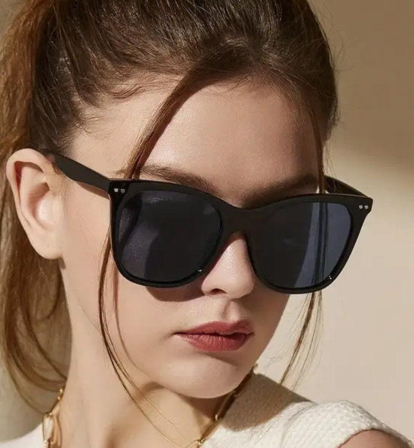 Sleek black cat-eye sunglasses with dark lenses and stud accents