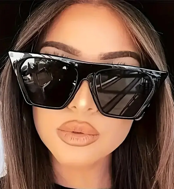 Futuristic oversized black geometric sunglasses with dark tinted lenses