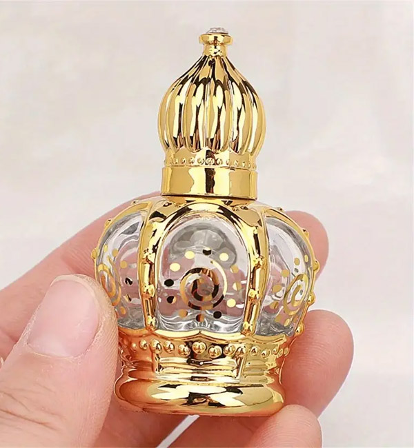 Ornate gold and glass perfume bottle with intricate crown design
