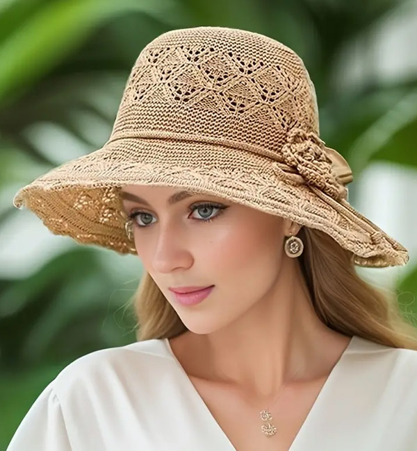 Beige woven sun hat with intricate lace patterns and flower accent