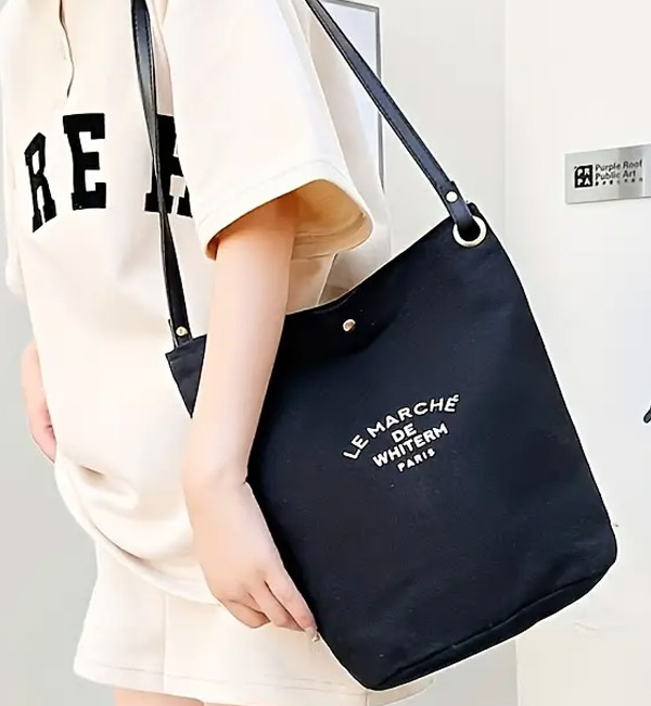 Black canvas shoulder bag with printed text design