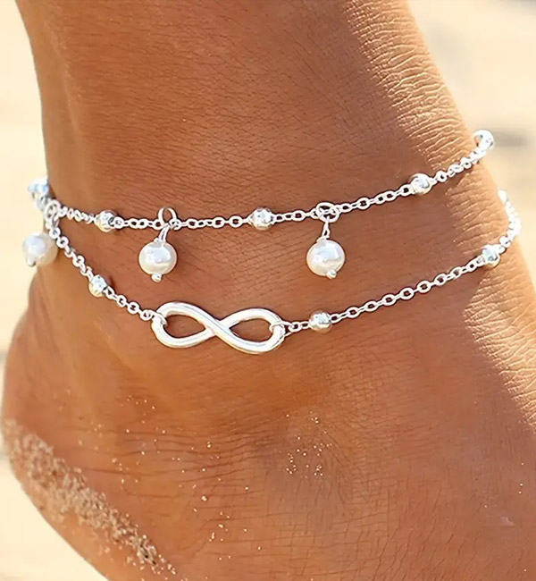 Silver anklet with infinity symbol and pearl charms, layered