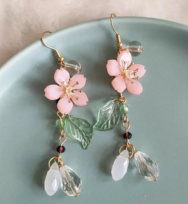 Delicate pink flower earrings with leaf accents