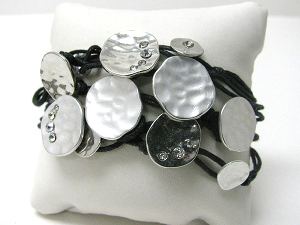 Architectural crystal deco on multi hammered metal disk and coated thread bracelet