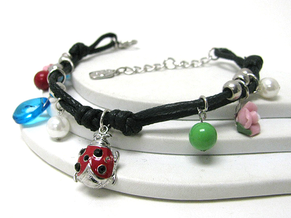 Lady bug and flower charm on coated thread bracelet