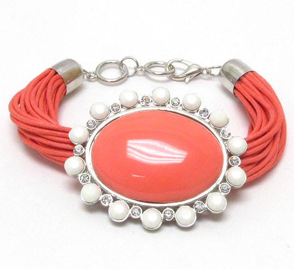 Crystal and puff oval acrylic pendant and multi cord bracelet